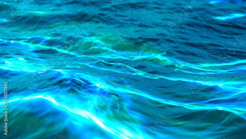 Abstract background of blue water surface with ripples and sunlight reflections