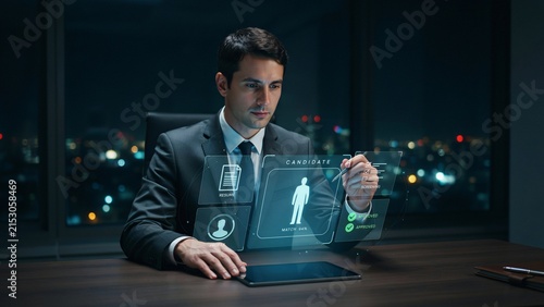 Businessman interacting with holographic candidate profile in dark office
