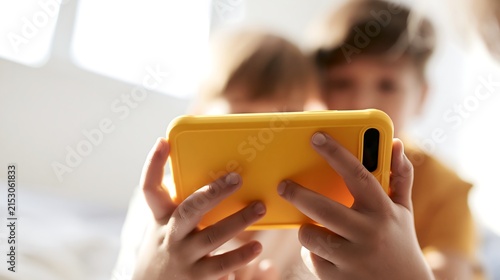 Two children share a digital tablet screen at home, illustrating kids’ gadget use, screen time, parental control, online safety and responsible technology habits.
