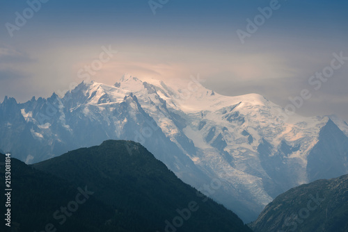 Majestic Mont Blanc Massif Bathed in Soft Sunlight Behind Dark Mountain Silhouettes