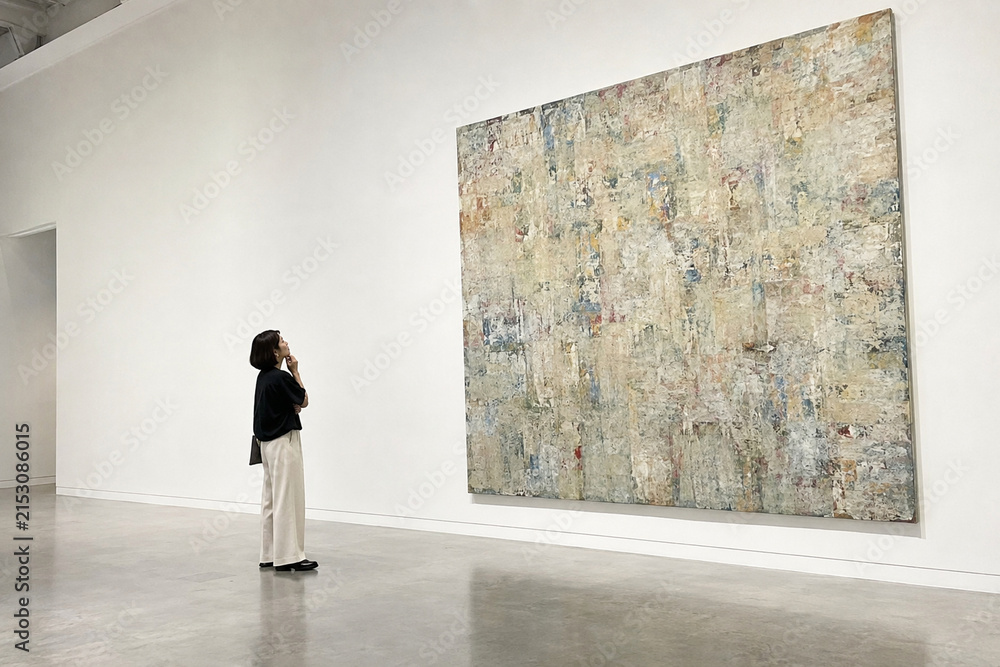Fototapeta premium 展示室で大きな絵画を見る女性