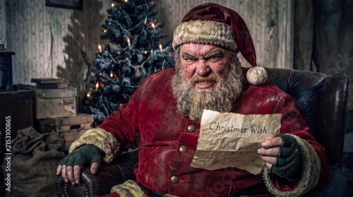 Sinister Santa Claus reading a dark Christmas wish letter