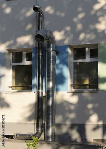 Building facade with metallic ventilation pipes and windows