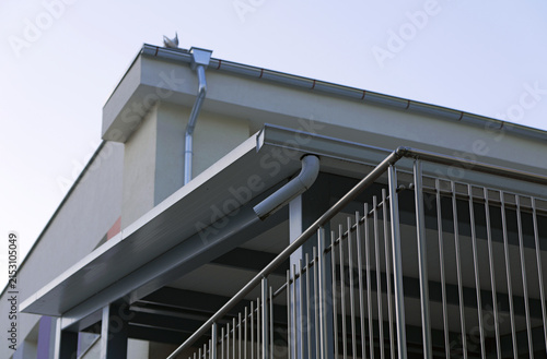 Building exterior with roof gutter and metal balcony railing