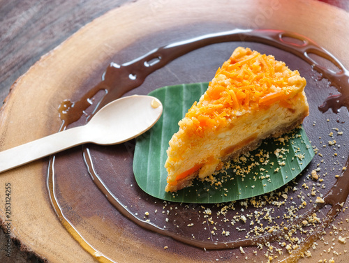 Slice of creamy carrot and salty egg cake served on a banana leaf with a rustic presentation.