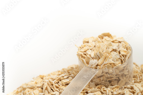 Foto Raw rolled oats in a transparent measuring scoop on a white background, with generous copy space for text and design