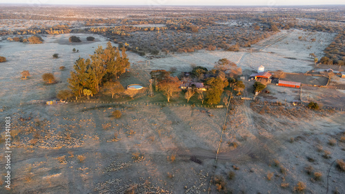 Photography Drone flight revealing farm buildings, windmills, and livestock pens frosted during a harsh South American winter