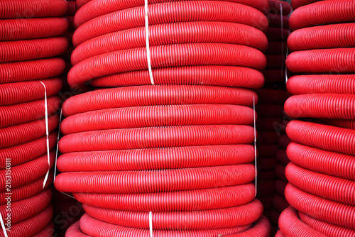 Stacks of red corrugated plastic pipes