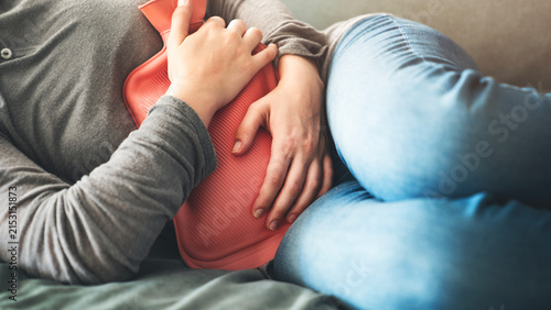Woman using hot water bottle for stomachache
