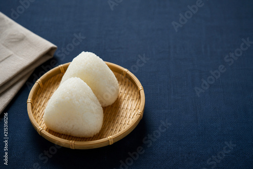 竹かごに置いた塩むすびと藍色の布
