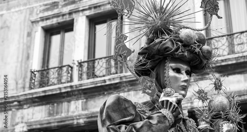 Silk whispers and golden masks dance lightly in the eternal shadow of the square