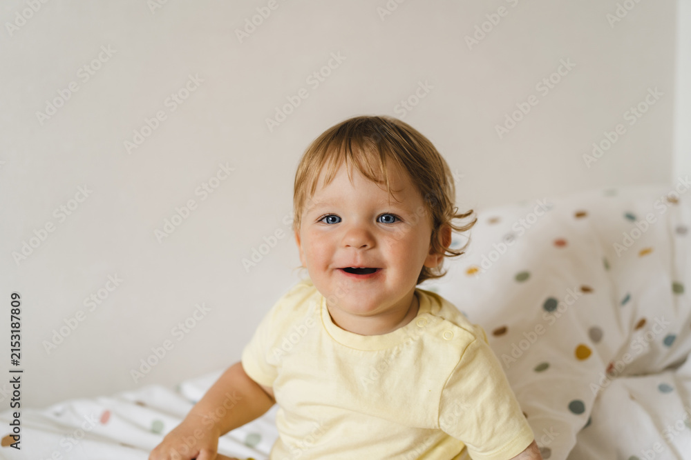 Fototapeta premium Happy toddler exploring the world, expressing emotions and developing cognitive skills through everyday play and discovery at home.