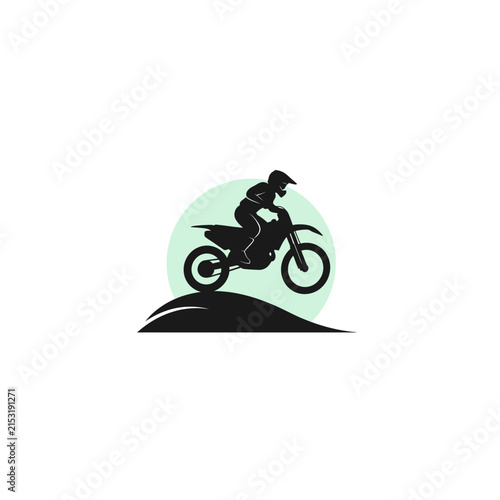 Motocross rider jumping a dirt bike over a hill