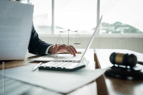 Konstfotografi Lawyer working on a laptop at a desk with a gavel, scales of justice, documents and calculator, representing legal services, business law and professional consultation