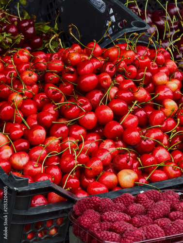 Fresh cherries, a popular summer berry, on a market counter.