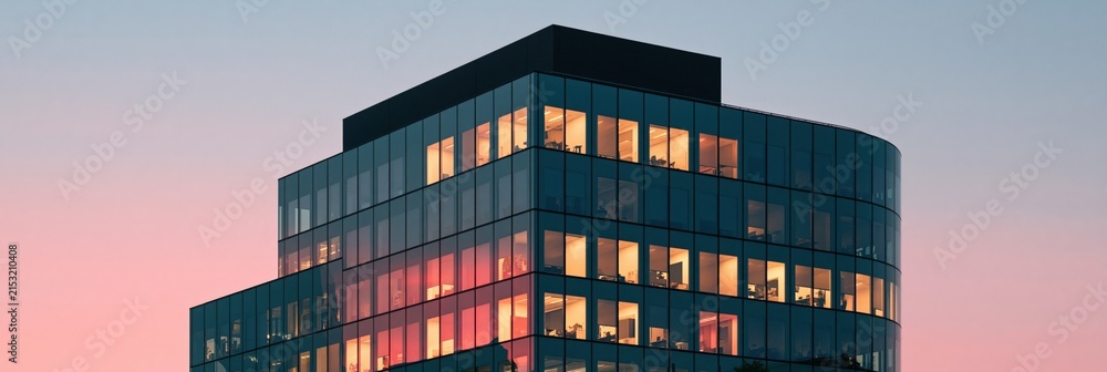 Fototapeta premium Modern multistory office building with lit interiors at sunset for corporate banner and website background