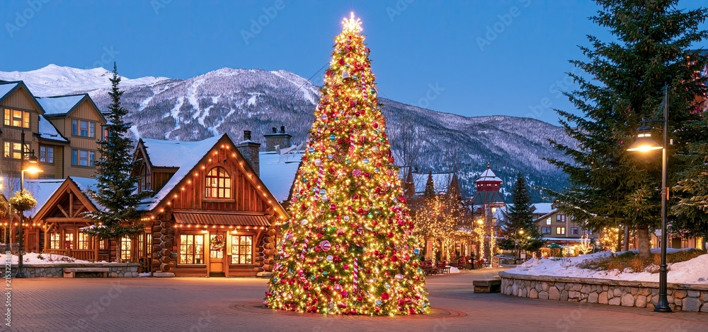 Obraz premium A snowy town square decorated with glowing holiday lights and a festive Christmas tree.