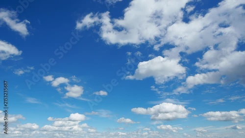 Beautiful abstract background featuring fluffy white clouds drifting across a bright blue sky in a cinematic timelapse motion with soft natural lighting and airy atmosphere