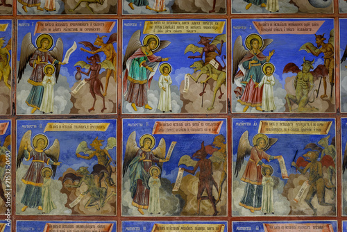 Фотография A fresco depicting angels battling demons, likely from a church or monastery, showing a narrative of good versus evil
