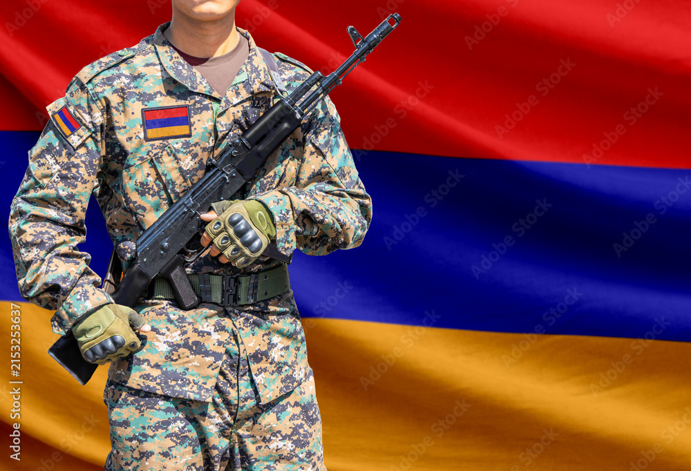 Fototapeta premium Armenia flag with soldier holding assault rifle