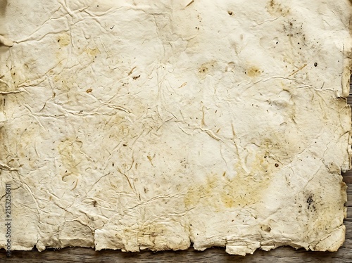 A detailed texture of a wrinkled and stained vintage paper sheet with rough edges, wrinkled
