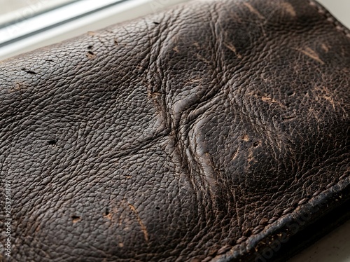 Dark brown leather surface with visible grain and texture material background abstract close-up