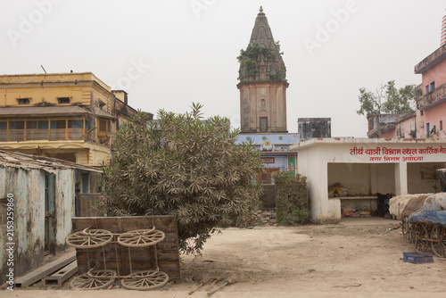AYODHYA, INDIA - OCT 2019: Old wooden cart wheels stand near a temple spire in the historic city