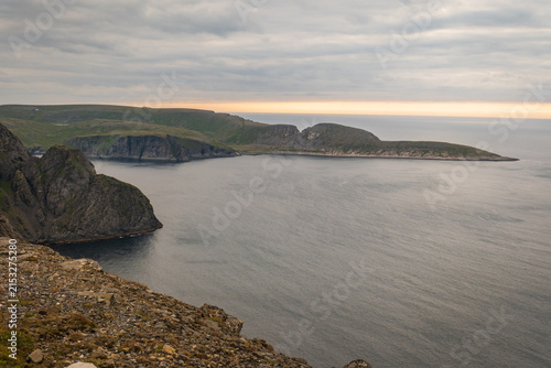 High-angle vista looking down at Knivskjellodden headland stretching into the Barents Sea from the North Cape plateau in Finnmark, Norway.