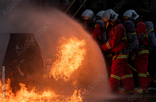 Konstfotografi Firefighters use a water hose to suppress an industrial fire during emergency re