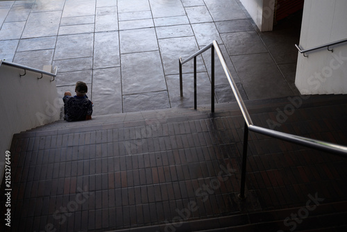 Senior man sitting alone on staircase in a public building