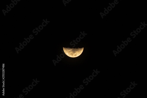 Part of the moon lighted up  on a clear sky
