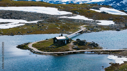 Obraz na płótnie Drone close-up of a lonely wooden cabin surrounded by icy glacial waters and sno