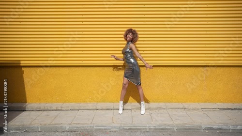 A Fashionable Model is Striking a Pose Against a Bright and Vibrant Yellow Background
