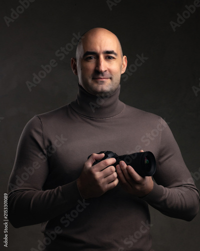 Professional photography and creative career, portrait of a male photographer holding a camera with confidence in a studio setting, Artistic vision and technical expertise in media production