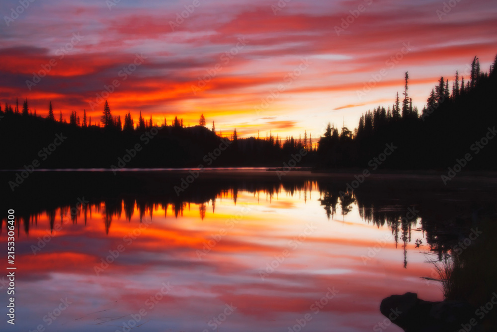Fototapeta premium Fiery sunset over alpine lake reflection