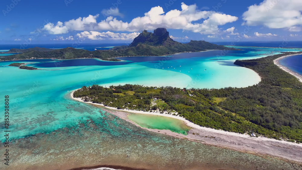 Fototapeta premium Luxury resort photo of French Polynesia tropical paradise island Bora Bora in Pacific Ocean. Beautiful photography with sandy beach, palm trees, coral reef, azure ocean, sky with clouds on horizon. 