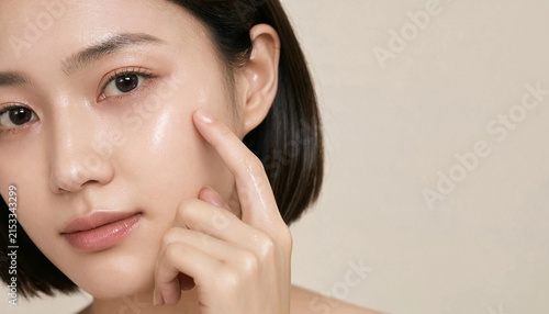 Macro portrait of Asian woman touching smooth glass skin on cheek for skincare cosmetic advertising and dermatology concept