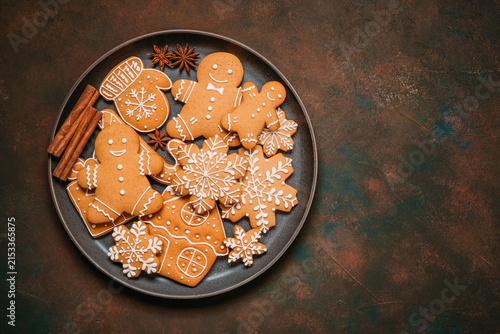 Christmas gingerbread cookies in a plate on dark grunge background, top view, flat lay, copy space