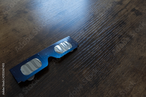 Solar eclipse viewing glasses on wooden table for astronomical observation safety