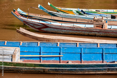 LUANG PRABANG, LAOS – Rows of colorful painted canoes line the riverbank in Luang Prabang, where wooden boats serve as everyday transportation in this UNESCO-listed Laotian city.