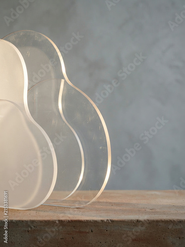 Three transparent acrylic guitar shapes stacked askew on a concrete surface