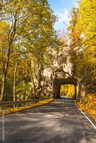 Country road and natural rock tunnel in autumn near Leibertingen in Upper Danube Nature Park, Swabian Alb, Germany