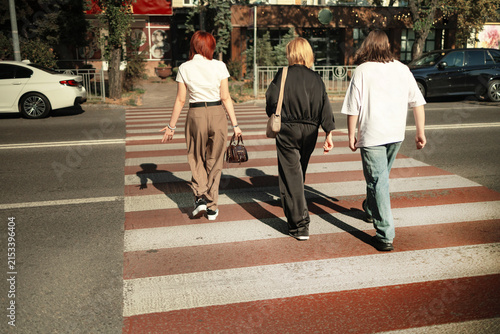 Foto Unrecognizable people crossing street on traffic light zebra