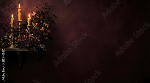 A dramatically lit still life features glowing burning candles and a beautiful abundant floral arrangement on a dark and moody tabletop surface