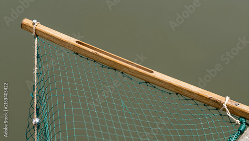 Wooden pole with green fishing net and twine