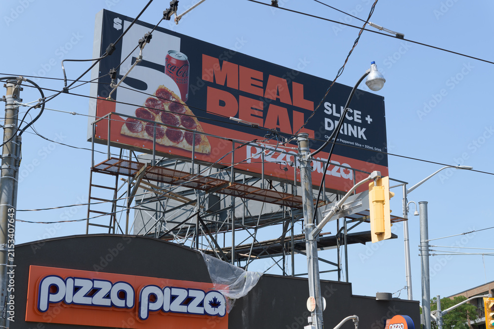 Fototapeta premium rooftop billboard and signage outside Pizza Pizza, a pizza restaurant chain, located here at 85 Danforth Av, Toronto (southwest corner of Broadview Av)