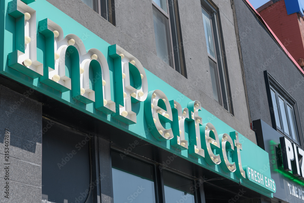 Fototapeta premium angled view of sign outside imPerfect Fresh Eats, a restaurant, located at 106 Danforth Av, Toronto