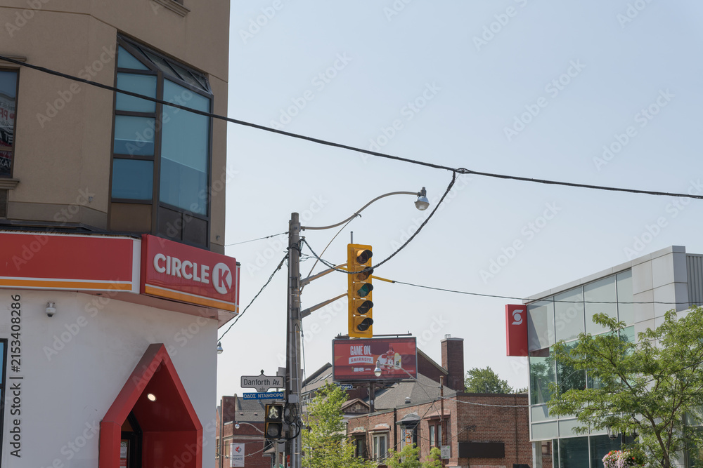 Fototapeta premium looking south on Pape from Danforth Av with signs of Circle K convenience store chain, Scotiabank, and a rooftop billboard, Toronto