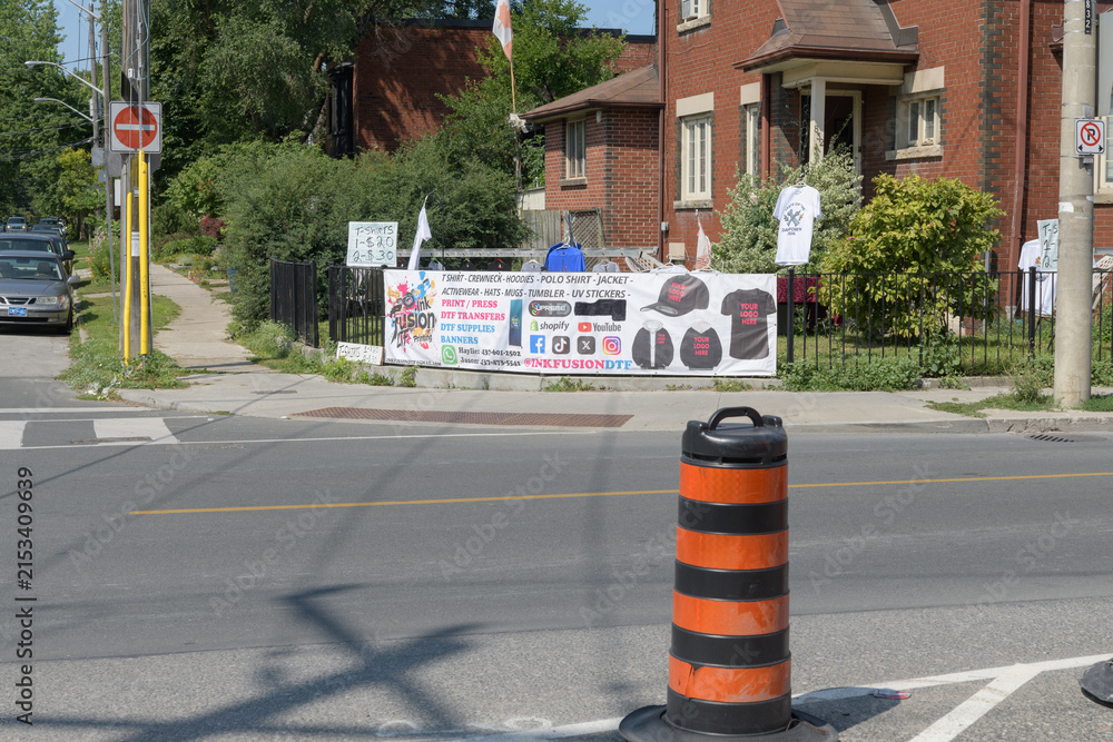 Fototapeta premium wide distant view of a t-shirt seller at Browning Av and Pape Av, Toronto