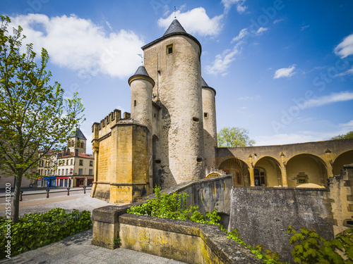 Historic Porte des Allemands in Metz, France, photographed on April 26, 2025. Medieval fortified city gate with round stone towers, defensive walls, bridge structures and arcades under a blue spring s